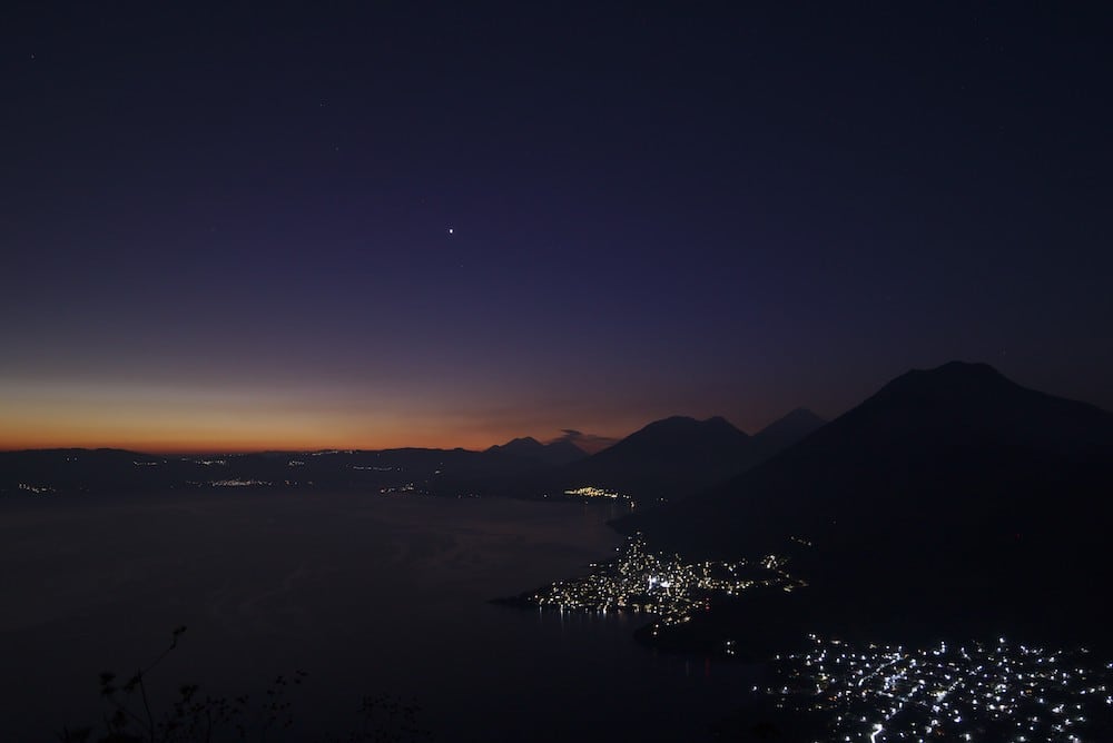 Sonnenaufgang mit den Lichtern von San Pedro La Laguna und San Juan La Laguna