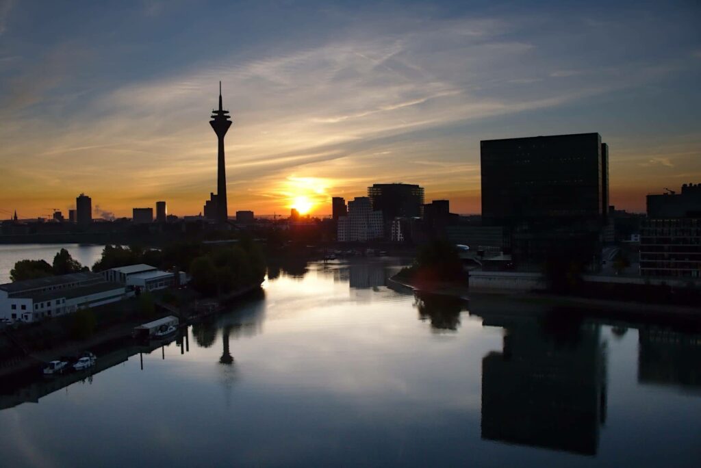 Die Sonne steigt zwischen Fernsehturm und Medienhafen in den Düsseldorfer Himmel.